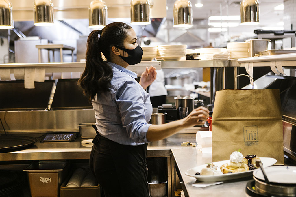 Restaurant kitchen action image waitress packaging take out orders. Restaurant Branding Photographer Chicago food photographer