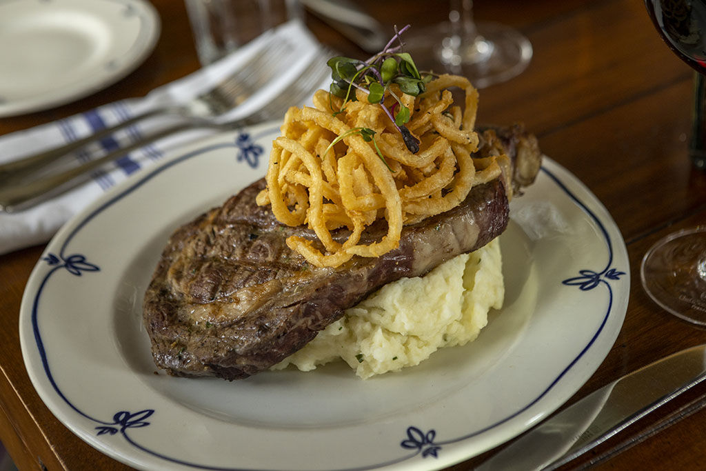 Steak with mashed potatoes crunchy crispy onions on a restaurant dining room table. Saint Paul, Minnesota. food photography near Chicago