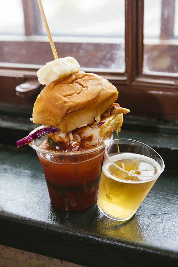 Vertical image of a bloody Mary sample topped with a pulled pork slider and beer chaser side during the Twin Cities Bloody Mary festival October 2021.