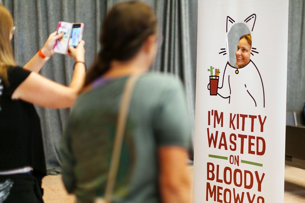 At the Twin Cities Bloody Mary Festival event goers pose with the Kitty Wasted sign for selfies, Saint Paul Union Depot Station October 2021.